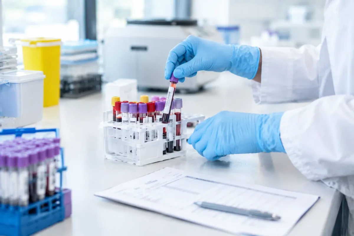 Blood sample vials being placed in a rack beside a lab requisition, the standard tests behind metabolic health